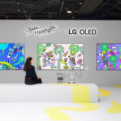 A woman admiring Steven Harrington's vibrant artwork displayed on LG OLED screens inside a creatively designed exhibition space.